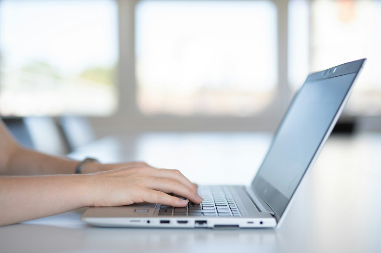 Hands typing on a laptop