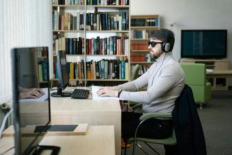 Young man working at a desk in headphones
