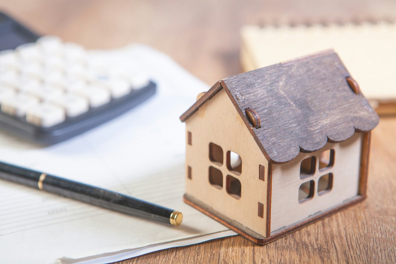 Calculator beside a small model house