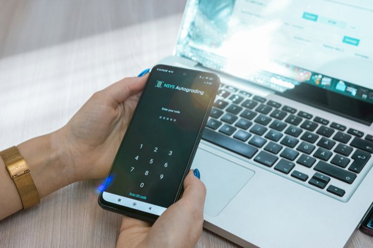 Phone held over a laptop