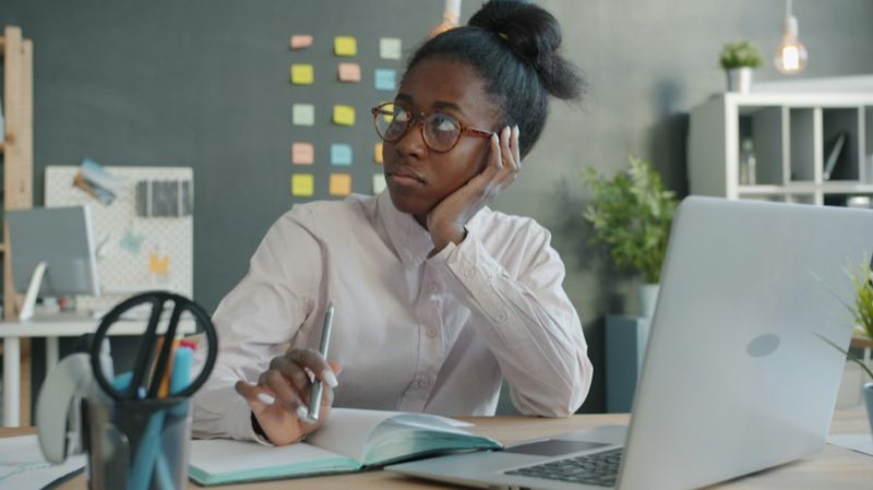 Woman at a desk on a phone call, notes beside her
